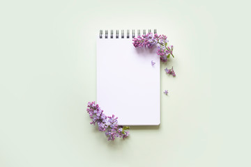 notebook with lilac flower on a mint green background