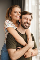 Photo of romantic cute couple smiling and hugging while standing