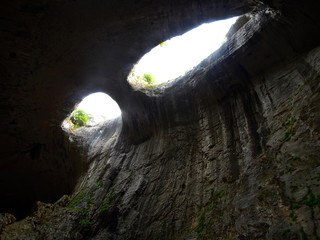 Closeup view from the right side on the formation called Eyes of the God inside the karst cave Prohodna, Bulgaria