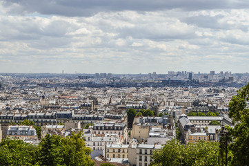 Fototapeta na wymiar Paris skyline, view from the Sacre Coeur on Montmartre hill, France. Basilica of Sacre Coeur is one of the landmarks in Paris. Aerial view of Paris in summer. Panorama of Paris city on a cloudy day.