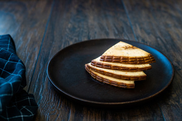 Spicy Circassian Triangle Smoked Cheese Slices on Dark Wooden Plate with Spices.