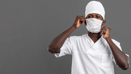 Specialist black male doctor arranging the mask
