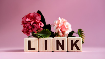 Link text on wooden cubes on a pink background with flowers