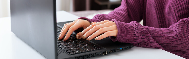 Woman working or learning from home using laptop. Freelancer have remote work, online education, work on maternity leave. Female hands typing on keyboard at home office. Long web banner
