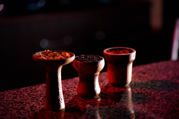 Clay bowl for hookah with tobacco and accessories for making hookah.