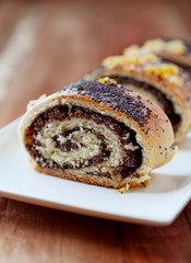 Poppy seed roll on wooden background. Close up.	