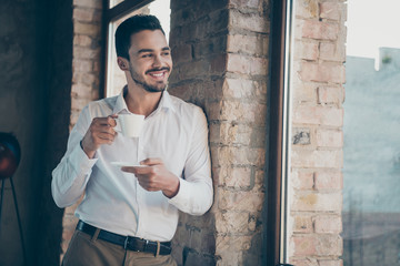 Profile side view of his he nice attractive confident elegant cheerful cheery man employee drinking caffeine latte good day at modern loft brick industrial style interior workplace station