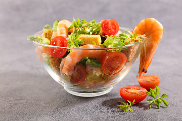 bowl of salad with shrimp, tomato and crouton
