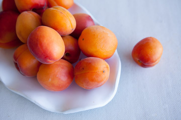 Fresh and juicy apricots in a ceramic plate. Natural light