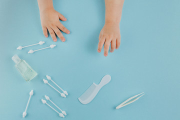 Baby play with toiletries, toys and health care accessories on blue background.