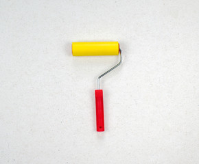 Tool, roller for smoothing wallpaper. Paint roller with red handle and yellow smooth nozzle...