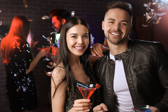 Happy Young Couple With Cocktails In Night Club