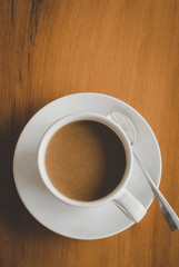A cup of coffee with coasters for coffee isolated on wooden table, flat lay and top down vertical view.