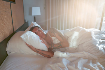 Obraz na płótnie Canvas Sleeping woman enjoying healthy nap in cozy bed in the morning