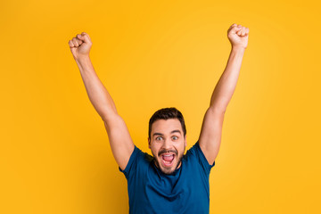 Close-up portrait of his he nice attractive glad overjoyed cheerful cheery guy celebrating raising hands up having fun isolated over bright vivid shine vibrant yellow color background