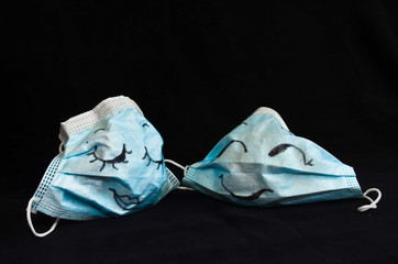 Two funny protection masks against Corona, with faces, like a man and a woman, are flirting...