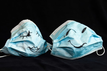 Two funny protection masks against Corona, with faces, like a man and a woman, are flirting...