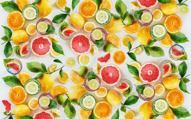 Citrus fruits background made with whole, halves and slices of various citrus with green leaves. Top view. Flat lay. Healthy eating. Vitamin. Drink ingredients.