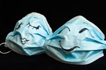 Two funny protection masks against Corona, with faces, like a man and a woman, are flirting...