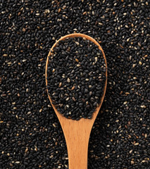 Spoon placed over black sesame background