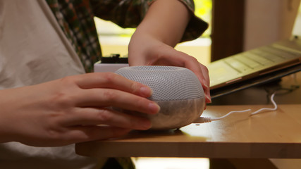 Obraz premium Female freelancer in kitchen turning on essential oil diffuser.