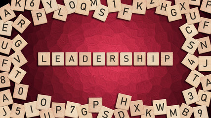 Leadership written with wooden tiles over red background.