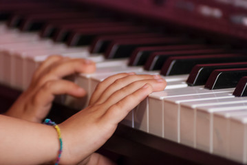 Hands of a caucasian child playing the electric piano