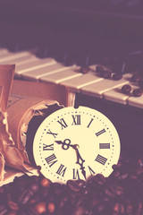A clock with Roman numerals and a piano, coffee beans vintage 