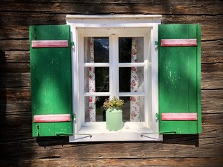 Typische grüne Fensterläden an traditionellem österreichischem alpinen alten Holzhaus im Salzkammergut, Oberösterreich