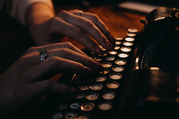 Young Woman typing "the end" on typewriter