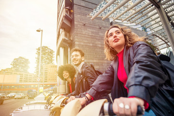 Three caucasian freinds outdoor riding bike street