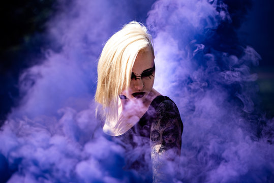 Young Woman With Make-up Standing Amidst Smoke