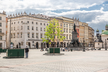 Fototapeta na wymiar Almost empty market square in krakow during pandemic (coronavirus, covid-19) time. A sunny warm day in Krakow, Lesser Poland, Poland.