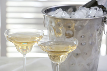 Bucket with ice and glasses of champagne in restaurant