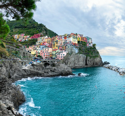 Fototapeta na wymiar The best panorama of Italy. Manarolla. Ligurian coast. Cinque Terre National Park. Stone path to the sea. Medieval town on a rock by the sea.