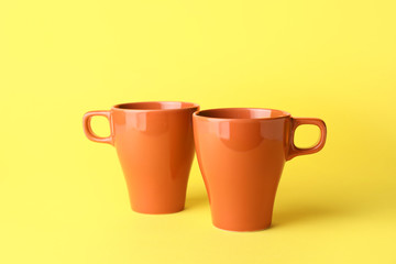 Blank cups on color background