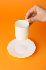 Female hand with blank cup on color background