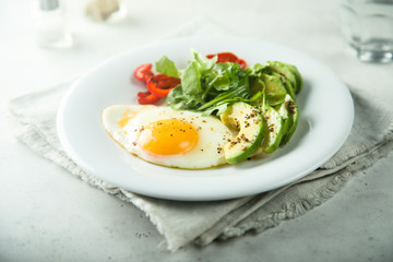 Fried egg with avocado and green salad