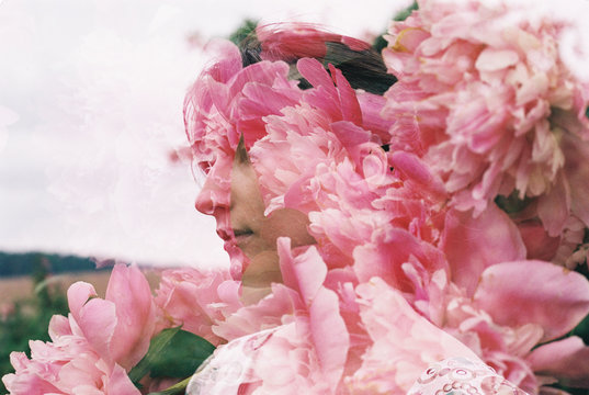 Double Exposure Image Of Woman And Pink Flowers Standing Outdoors