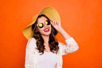 Photo of curly wavy cheerful positive nice charming pretty girlfriend in eyewear smiling toothily looking at the sun isolated over vivid orange color background