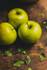 Fresh green apples on the rustic wood table.  