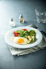 Fried egg with avocado and green salad