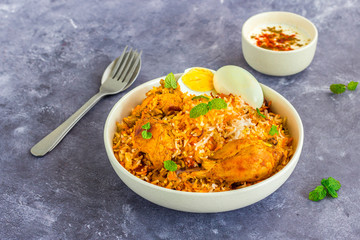 Chicken Biryani with Raita and Eggs on Dark Background, Close Up Photography
