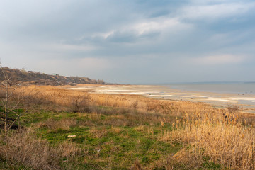 Fototapeta na wymiar Rural Landscape on a Waterside of Estuary in Cloudy Moody Spring Day