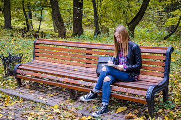 Teen girl reading a book at park