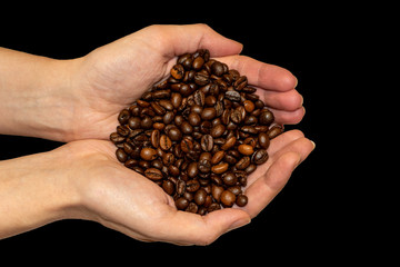 top view on roasted coffee in hands close-up on a black background