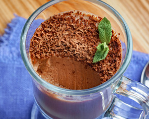 homemade dessert of yogurt and cocoa in a glass bowl on a wooden board