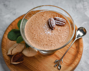 homemade dessert of yogurt and cocoa in a glass bowl on a wooden board