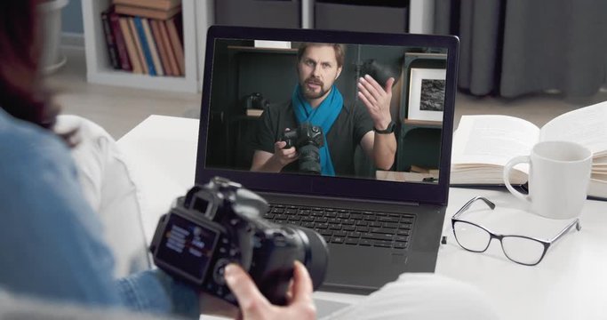 Woman watching photo camera review, remote home learning, photography tutorial profit