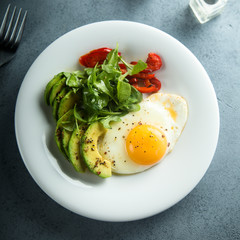 Fried egg with avocado and green salad